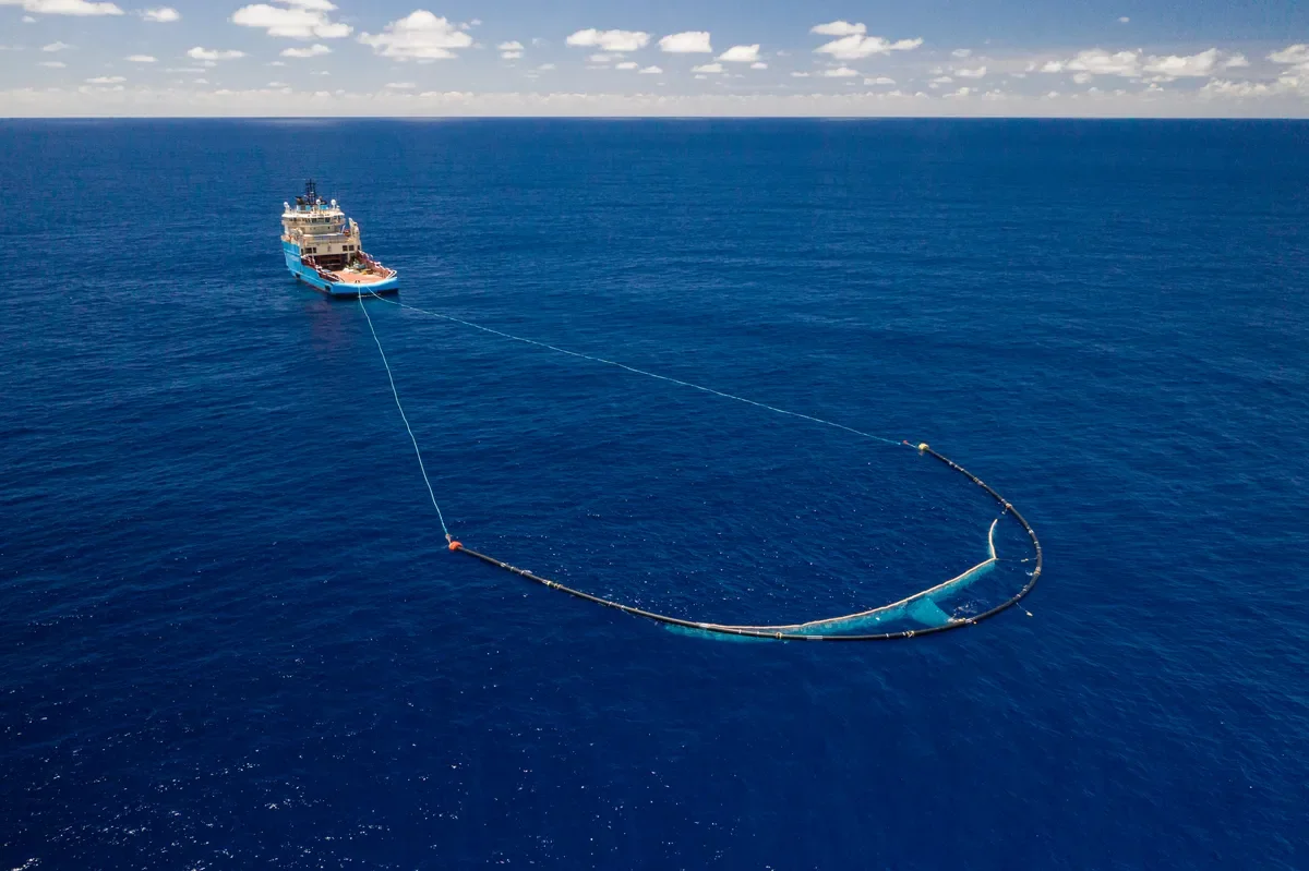 Un barco remolca una plataforma en forma de U en el océano
