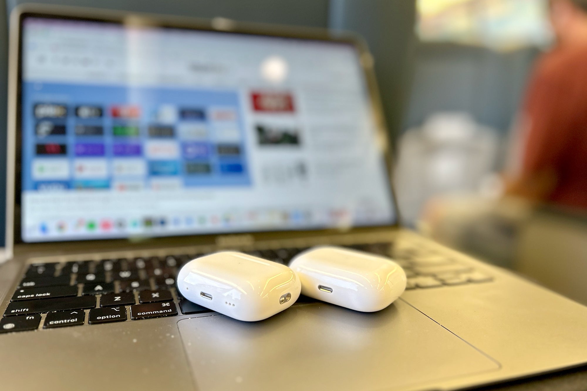 AirPods Pro 2 cases side-by-side on MacBook on Amtrak